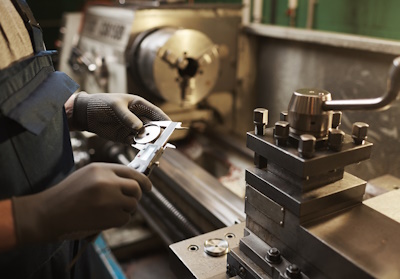 Close-up of worker measuring metal detail with special equipment